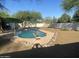 Inviting backyard pool featuring diving board, rock surround, and lush landscaping for relaxation and entertainment at 7044 E Ann Way, Scottsdale, AZ 85254