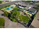 Aerial perspective of a home featuring a pool, tennis court, solar panels, and mature trees at 8001 E Voltaire Ave, Scottsdale, AZ 85260