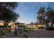 Expansive backyard featuring a covered outdoor living area, bar, fire pit, synthetic grass and an in-ground pool at 8001 E Voltaire Ave, Scottsdale, AZ 85260