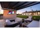 Comfortable outdoor space with a built-in TV, modern furniture and a beautifully landscaped lawn, perfect for relaxation at 8001 E Voltaire Ave, Scottsdale, AZ 85260