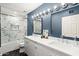 Elegant bathroom with dual sinks, white marble counters, and a glass-enclosed shower/tub at 8001 E Voltaire Ave, Scottsdale, AZ 85260