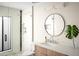 Bright bathroom features a modern vanity with a round mirror and a glass-enclosed shower at 8001 E Voltaire Ave, Scottsdale, AZ 85260