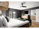 Cozy bedroom features a king bed, dark grey walls, sheer curtains, and attached bathroom at 8001 E Voltaire Ave, Scottsdale, AZ 85260