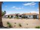 Charming single-story home with desert landscaping, brick driveway and walkway, under a bright blue sky at 8001 E Voltaire Ave, Scottsdale, AZ 85260