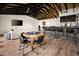 Open game room with high ceilings, a pool table, poker table, bar area, and comfortable seating at 8001 E Voltaire Ave, Scottsdale, AZ 85260