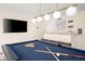Well-lit game room with a pool table, television, bar area, and modern light fixtures at 8001 E Voltaire Ave, Scottsdale, AZ 85260