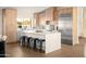 Modern kitchen featuring an island with breakfast bar, stainless steel appliances, and light wood cabinetry at 8001 E Voltaire Ave, Scottsdale, AZ 85260