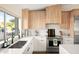 Bright kitchen showcasing stainless steel appliances, light wood cabinets, quartz counters, and a garden view at 8001 E Voltaire Ave, Scottsdale, AZ 85260