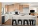 Modern kitchen featuring wooden cabinets, white countertops and island with black stools, and stainless steel appliances at 8001 E Voltaire Ave, Scottsdale, AZ 85260