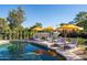 Stunning in-ground pool featuring several lounge chairs with bright yellow umbrellas perfect for entertaining poolside at 8001 E Voltaire Ave, Scottsdale, AZ 85260