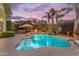 A backyard oasis with a freeform pool, rock features, and mature landscaping at sunset at 824 W Whitten St, Chandler, AZ 85225