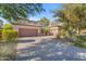 Home exterior featuring a three-car garage, desert landscaping, and a spacious driveway at 824 W Whitten St, Chandler, AZ 85225