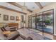 Cozy living room features exposed beams, hardwood floors, and a sliding glass door to the patio at 824 W Whitten St, Chandler, AZ 85225