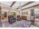 Inviting living room featuring wood beams, colorful rug, piano, and comfortable leather chairs at 824 W Whitten St, Chandler, AZ 85225