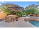 Outdoor kitchen and in-ground pool with a waterfall feature at 824 W Whitten St, Chandler, AZ 85225