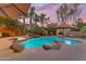 A backyard oasis with a freeform pool, rock features, and mature landscaping at dusk at 824 W Whitten St, Chandler, AZ 85225