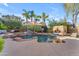 Relaxing pool area with cascading waterfall, covered daybed, and mature palm trees at 824 W Whitten St, Chandler, AZ 85225