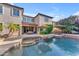 Back of house featuring a pool and rock waterfall with lush landscaping and an umbrella covered seating area at 824 W Whitten St, Chandler, AZ 85225