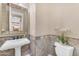 Cozy powder room with decorative tile, pedestal sink, and elegant mirror at 824 W Whitten St, Chandler, AZ 85225