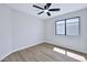 This bedroom features wood floors, a window, ceiling fan, and neutral paint at 8501 W Highland Ave, Phoenix, AZ 85037