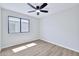 This bedroom features wood floors, a window, ceiling fan, and neutral paint at 8501 W Highland Ave, Phoenix, AZ 85037