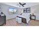 Bright bedroom with plush bedding, stylish accents, a ceiling fan, and back yard view at 8501 W Highland Ave, Phoenix, AZ 85037