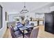 Open-concept dining room with modern lighting, dark wood table, and seamless flow into the kitchen and living areas at 8501 W Highland Ave, Phoenix, AZ 85037