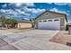 Exterior of a well-kept home featuring a spacious driveway, desert landscaping, and an attached two-car garage at 8501 W Highland Ave, Phoenix, AZ 85037