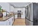 Well-lit kitchen features stainless steel appliances, white cabinetry, granite countertops, and hardwood flooring at 8501 W Highland Ave, Phoenix, AZ 85037