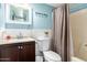 Bathroom features a decorative mirror, blue walls, and toilet at 8818 W Pinchot Ave, Phoenix, AZ 85037