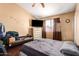 Cozy bedroom features a neutral color scheme, a TV on top of a dresser, and a window with blinds at 8818 W Pinchot Ave, Phoenix, AZ 85037