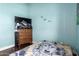Bedroom with blue painted walls, a TV, and a patterned bed spread at 8818 W Pinchot Ave, Phoenix, AZ 85037