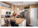 Open concept kitchen with white cabinets, stainless steel appliances, a wood countertop island, and pendant lights at 8818 W Pinchot Ave, Phoenix, AZ 85037