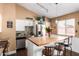 Modern kitchen features white cabinets, stainless steel appliances, a wood countertop island, and pendant lighting at 8818 W Pinchot Ave, Phoenix, AZ 85037