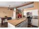Bright kitchen features white cabinets, stainless steel appliances, wood countertop island, and pendant lighting at 8818 W Pinchot Ave, Phoenix, AZ 85037