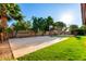 Backyard with a basketball court, lush lawn, mature trees, and a hammock, ideal for outdoor activities at 882 N Concord Ave, Chandler, AZ 85225