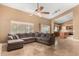 Open concept living room with a large sectional sofa, ceiling fan, and a view into the kitchen area at 882 N Concord Ave, Chandler, AZ 85225