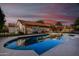 Backyard pool with view of home and patio surrounded by black metal fencing, reflecting a colorful sunset sky at 882 N Concord Ave, Chandler, AZ 85225