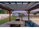 Pergola view of backyard featuring the pool, grassy area, and trampoline at 13 W Silverwood Dr, Phoenix, AZ 85045