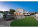 Spacious backyard featuring lush artificial turf, a pool, a trampoline, and a covered pergola at 13 W Silverwood Dr, Phoenix, AZ 85045