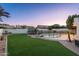 View of backyard featuring a grassy area, pool with safety fence, and trampoline at 13 W Silverwood Dr, Phoenix, AZ 85045