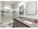Bright bathroom with a double sink vanity, decorative mirrors, and a tiled glass enclosed shower at 13 W Silverwood Dr, Phoenix, AZ 85045