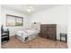 Cozy bedroom featuring a window, ceiling fan, rustic dresser, and a comfortable bed with storage drawers at 13 W Silverwood Dr, Phoenix, AZ 85045