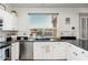 Bright kitchen with stainless appliances, white cabinets, and a view of the backyard pool at 13 W Silverwood Dr, Phoenix, AZ 85045