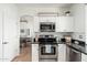Cozy kitchen with stainless steel appliances, dark countertops, and a view to the dining room at 13 W Silverwood Dr, Phoenix, AZ 85045