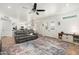 Open-concept living room with leather sectional, fireplace, and tile flooring leading to the kitchen and dining area at 13 W Silverwood Dr, Phoenix, AZ 85045