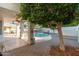 Covered patio overlooking a fenced-in pool area, enhanced with a mature tree and brick pavers at 13 W Silverwood Dr, Phoenix, AZ 85045