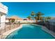Backyard pool with a safety fence, tropical palm trees, and a covered patio area at 13 W Silverwood Dr, Phoenix, AZ 85045