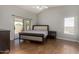 Spacious bedroom with laminate floors, a sliding glass door, and a large window at 13373 W Boca Raton Rd, Surprise, AZ 85379