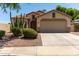 Charming single-story home with a two-car garage, desert landscaping, and a tile roof at 13373 W Boca Raton Rd, Surprise, AZ 85379